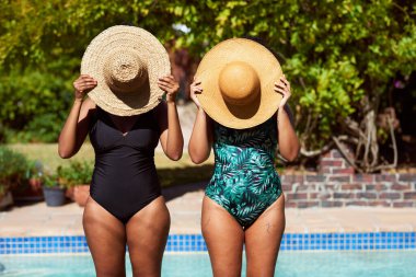 İki arkadaş yaz hasır şapkalarının arkasına saklanıp poz veriyor ve gün ışığında bilardo oynuyorlar. Yüksek kalite fotoğraf