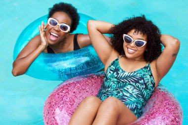 İki genç siyah arkadaş havuzda şişme halkalarla yüzüyor, eğleniyorlar. Yüksek kalite fotoğraf