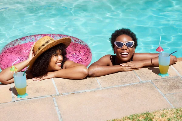 stock image Two Black friends lean on the side of the pool, relaxing in water with mocktails. High quality photo