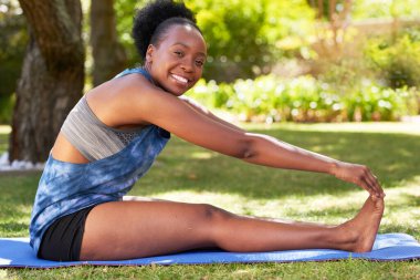 Genç siyahi kadın, yaz tatilinde açık havada yoga parkında ayağa uzanıyor. Yüksek kalite fotoğraf