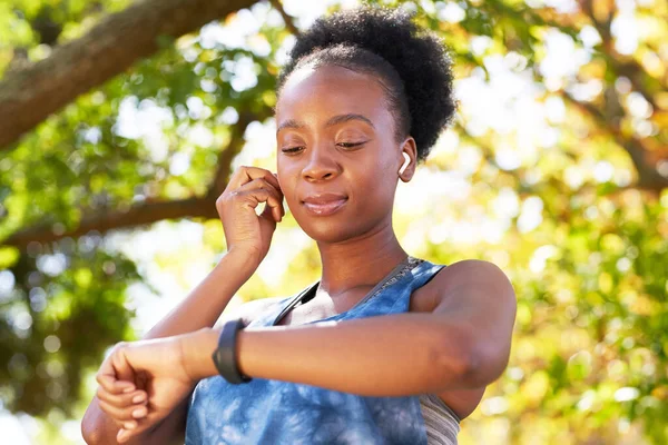 stock image Portrait of a young Black woman getting ready for run with earphones, in park. High quality photo