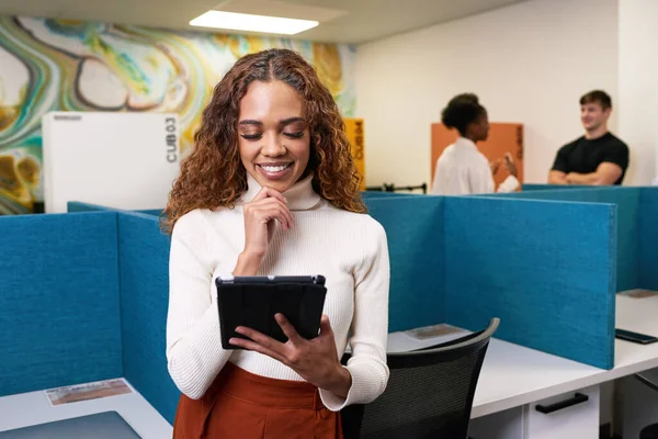 若い多民族の女性は オフィスでのデジタルタブレット 笑顔の記事を読み取ります 高品質の写真 — ストック写真