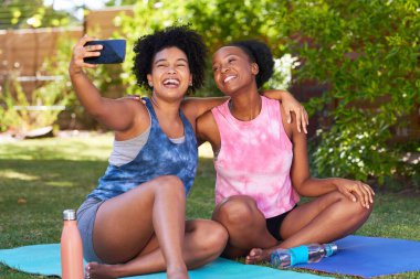 İki güzel siyah kadın parkta yoga yaptıktan sonra selfie çekiyor, arkadaşlık. Yüksek kalite fotoğraf
