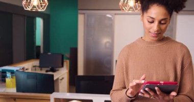 Ofiste dijital tablet kullanan çok ırklı genç bir kadının görüntüsü. Yüksek kalite 4k görüntü