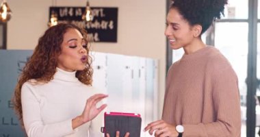 Orta boy fotoğraf, iki çok ırklı meslektaşı ofiste çalışma konusunu tartışıyor, dijital tablet. Yüksek kalite 4k görüntü