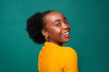 Stüdyoda gülümseyen güzel siyah kadın, deniz mavisi arka plan, moda tarzı portre. Yüksek kalite fotoğraf