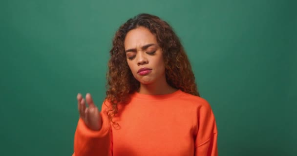 Молода Жінка Покриває Обличчя Рукою Обличчям Долоні Зеленим Студійним Фоном — стокове відео