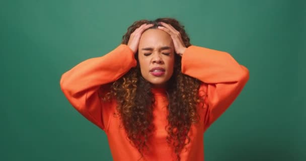 沮丧而愤怒的年轻女子将头发从绿色工作室的背景中撕破 高质量的4K镜头 — 图库视频影像
