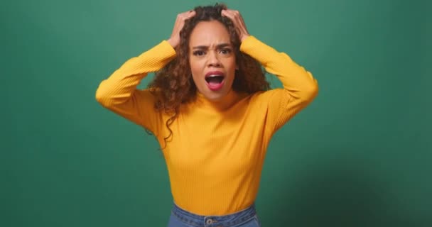 沮丧而愤怒的年轻女子将头发从绿色工作室的背景中撕破 高质量的4K镜头 — 图库视频影像