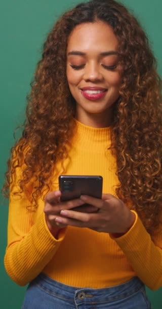 Hermosa Mujer Joven Mensajes Texto Teléfono Celular Sonriente Fondo Estudio — Vídeos de Stock