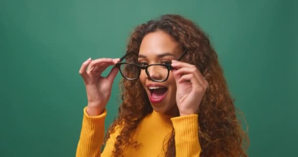 美しい多民族女性は眼鏡 緑のスタジオの背景を試しています 高品質の4K映像 — ストック動画
