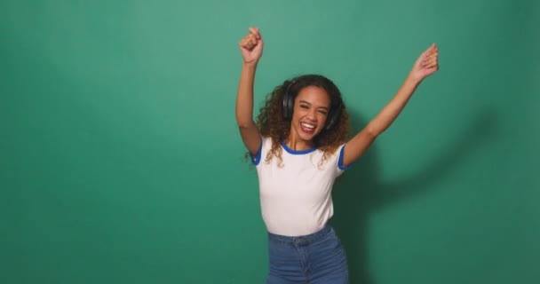 Широкий Снимок Молодая Расистка Танцует Наушниках Зеленый Студийный Фон Высококачественные — стоковое видео