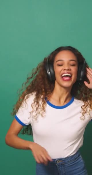 Широкий Снимок Молодая Расистка Танцует Наушниках Зеленый Студийный Фон Высококачественные — стоковое видео