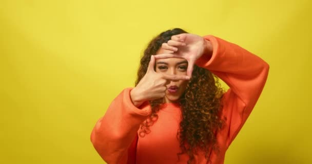 Молода Багаторасова Жінка Обрамляє Обличчя Прямокутними Пальцями Жовтою Студією Високоякісні — стокове відео