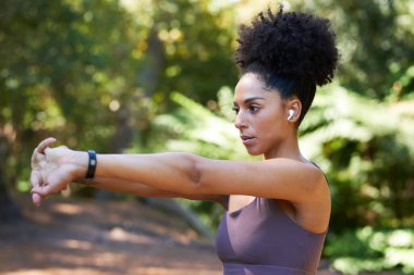 Ciddi çok ırklı kadınlar ormanda koşmadan önce kollarını uzatıp egzersiz yaparlar. Yüksek kalite fotoğraf