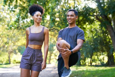 Parkta koşmadan önce bacakları esneten güzel bir çift, fitness koşusu. Yüksek kalite fotoğraf