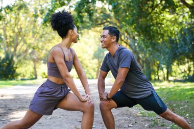 Güzel bir çift parkta koşmadan önce esneme hareketleri yapar. Yüksek kalite fotoğraf