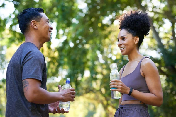 Fitness team cools down after exercise in park, beautiful couple drinking water . High quality photo