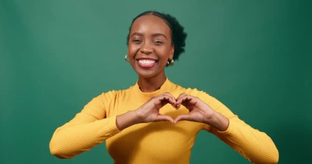Young Black Woman Forms Heart Hands Smiling Green Studio Background — Stock Video