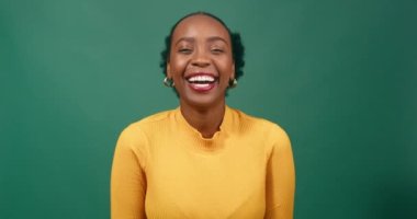 Gülen genç kadın, siyah güzel, yeşil arka plan stüdyosu. Yüksek kalite 4k görüntü