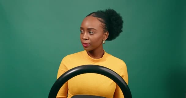 緑のスタジオの背景を避けるためにショックで若い女性ドライバーブレーキ 高品質の4K映像 — ストック動画