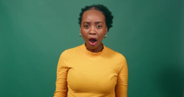 Shocked Confused Young Woman Puts Hands Mouth Green Studio Background — Stock Video