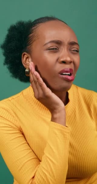年轻的黑人女人在疼痛 工作室绿色背景橙的情况下揉搓下巴 高质量的4K镜头 — 图库视频影像
