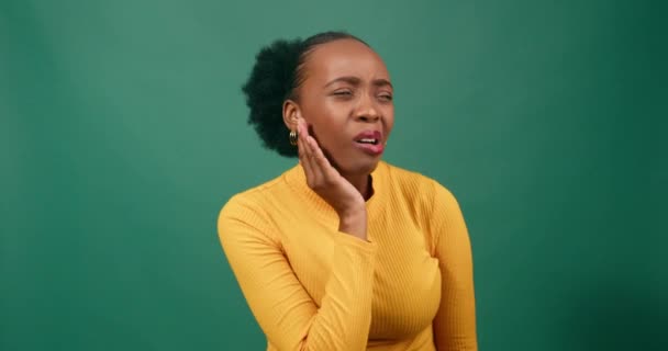 若い黒人女性は痛み スタジオグリーンの背景オレンジで顎をこすります 高品質の4K映像 — ストック動画