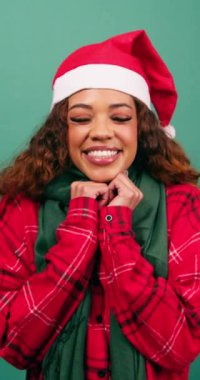 Çenesinin altında elleri olan gülen bir kadının şirin portresi, yeşil stüdyo noeli. Yüksek kalite 4k görüntü