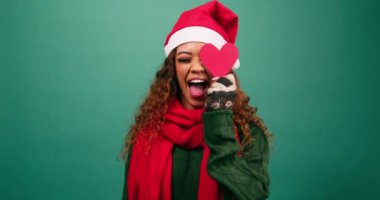 Hoş, genç, çok ırklı bir kadın, kalp şekilleriyle oynuyor, Noel stüdyosu. Yüksek kalite 4k görüntü