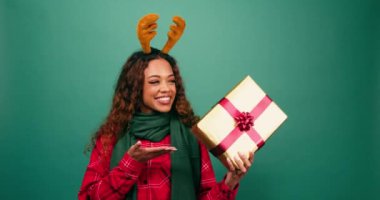 Heyecanlı genç kadın, Noel hediyesine el kaldırıyor, stüdyo çekimi yapıyor. Yüksek kalite 4k görüntü