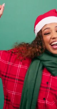 Stüdyoda dans eden mutlu genç bir kadın, Noel temalı Noel Baba şapkası. Yüksek kalite 4k görüntü