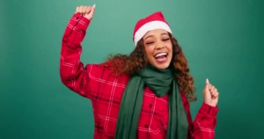 Stüdyoda dans eden mutlu genç bir kadın, Noel temalı Noel Baba şapkası. Yüksek kalite 4k görüntü