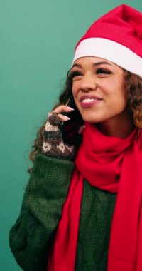 Mutlu genç kadın, Noel 'de, stüdyoda telefonda konuşurken ve gülerken heyecanlanıyor. Yüksek kalite 4k görüntü