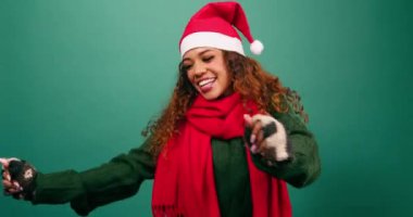 Stüdyoda dans eden mutlu genç bir kadın, Noel temalı Noel Baba şapkası. Yüksek kalite 4k görüntü