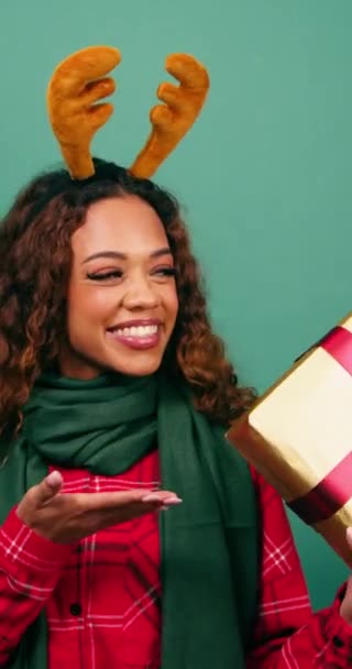 クリスマスプレゼント パームアップ スタジオショットへの興奮した若い女性のジェスチャー 高品質の4K映像 — ストック動画