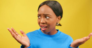 Şok olmuş bir kadın, inanamadığı için avuçlarını kaldırıyor, sarı stüdyo geçmişi var. Yüksek kalite fotoğraf