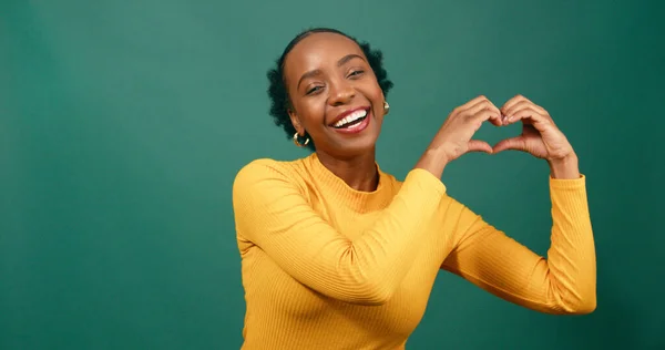Young Black Woman Forms Heart Hands Side Smiling Green Studio — Stock Photo, Image