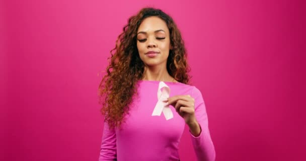 Multietnisk Kvinna Håller Bröstcancer Medvetenhet Band Till Kamera Rosa Studio — Stockvideo