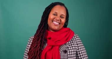 Genç bir kadın gülümsüyor ve Noel renklerinde poz veriyor. Stüdyo videosu. Yüksek kaliteli 4K görüntü.