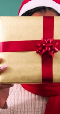Heyecanlı genç kadın hediye kutusunu tutuyor ve yüzünü gösteriyor, Noel hediyesi stüdyosu. Yüksek kalite 4k görüntü