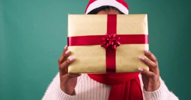 Heyecanlı genç kadın hediye kutusunu tutuyor ve yüzünü gösteriyor, Noel hediyesi stüdyosu. Yüksek kalite 4k görüntü