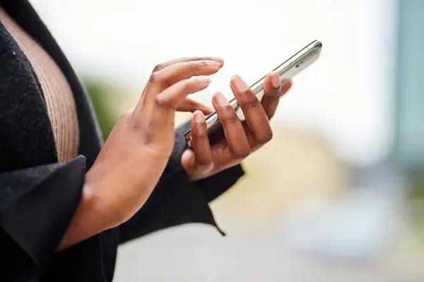 Cropped image of young Black woman in business wear holding cell phone. High quality photo