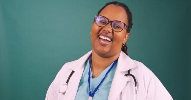 Beyaz önlüklü, gülümseyen ve gülen genç siyahi kadın doktor portresi. Yüksek kalite fotoğraf