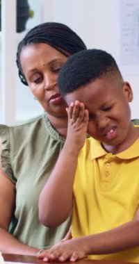 Annesi tarafından eşlik edilen genç bir çocuk, ofisinde bir doktorla görüşüyor..