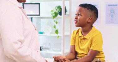 Genç çocuk check-up 'tan sonra doktoruna beşlik çakıyor. Pediatrik bakım, çocuk sağlığı ve doktor hasta ilişkisi.