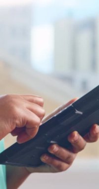 Yeşil önlüklü bir doktor bir tabletteki hasta bilgilerini güncelliyor.