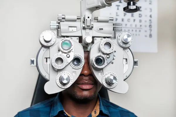 Profesyonel bir optometrist hassas bir göz muayenesi için gelişmiş ekipman kullanır. Ortam, görüş bakımı ve göz giysisi optimizasyonuna odaklanan iyi donanımlı bir optik klinik..
