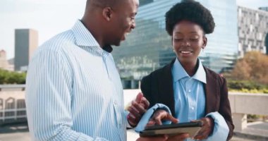 Bir işadamı ve işkadını gün boyunca kentin dışında duruyor ve bir tablet kullanıyor. Birlikte çalışıyorlar, iş konuşuyorlar ve teknolojiyi kullanıyorlar. Başarırlar ve kutlarlar..