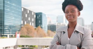 Kendine güvenen Afrikalı Amerikalı iş kadını Modern bir şehirde Katlanmış Silahlarla gülümsüyor